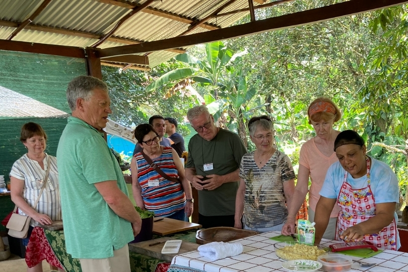 Travellers learning traditional cooking techniques from a local host in Costa Rica.