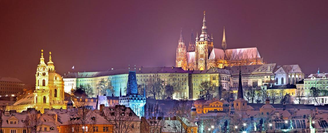 Illuminated Prague during Christmastime covered in snow.  