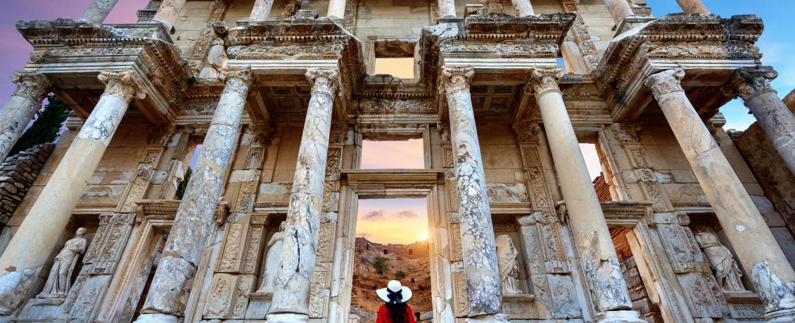 Lady wearing red dress standing in front of Celsus Library in Ephesus