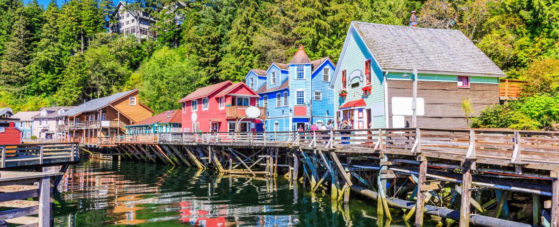 Wooden boardwalk along the waterfront in Ketchikan, Alaska, lined with bright colorful houses and businesses