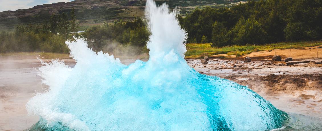 Geyser erupting in Iceland, with steam and hot water