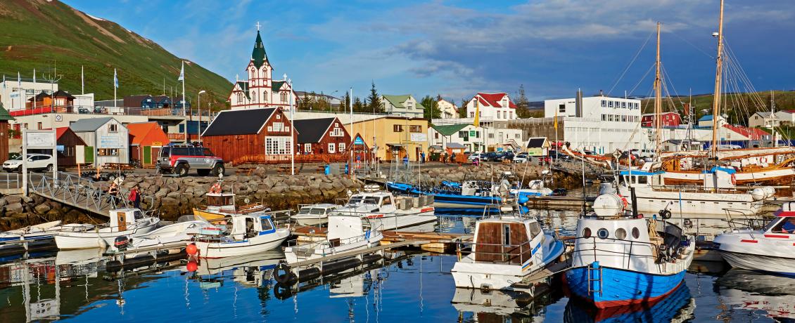 Colorful boats docked in the harbor of Husavik