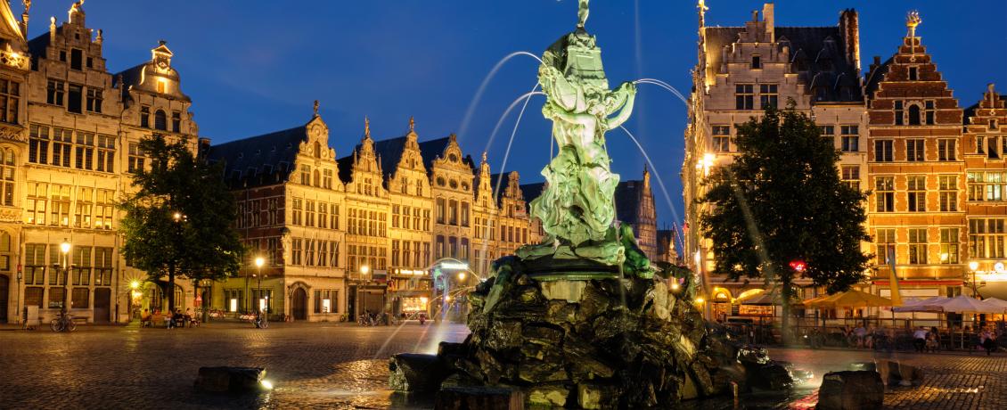Brabo Fountain illuminated at night in Antwerp’s Grote Markt, surrounded by historic guild houses