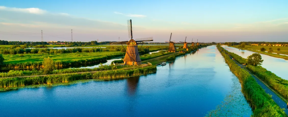 Row of historic Dutch windmills lining a long canal at Kinderdijk
