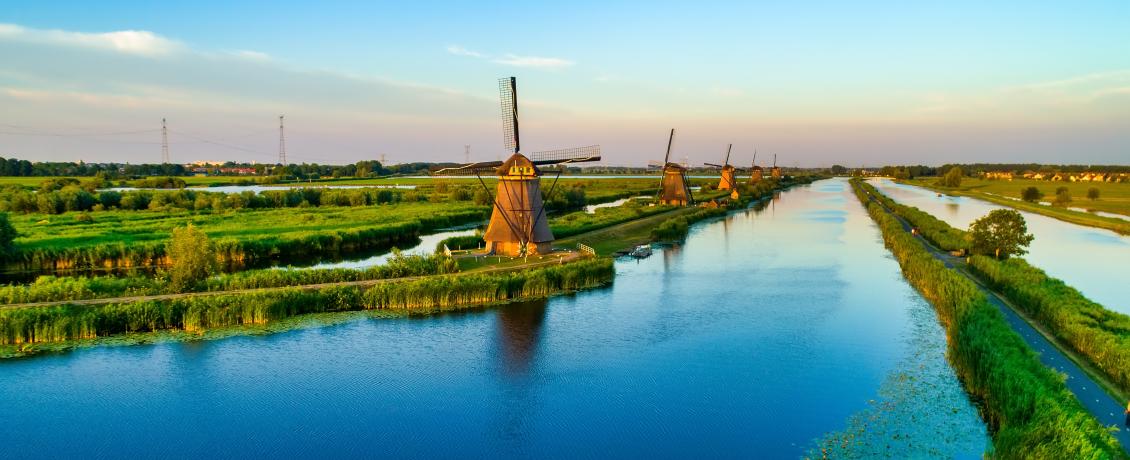 Row of historic Dutch windmills lining a long canal at Kinderdijk