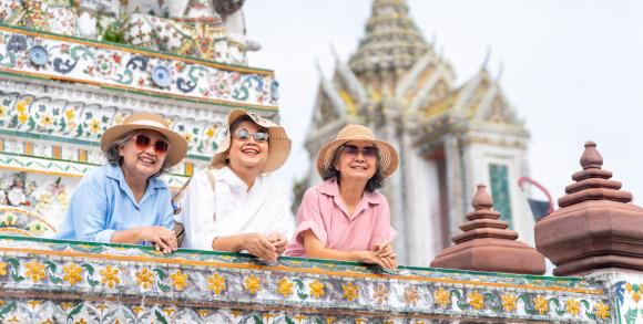 Three smiling women visiting a Thai temple