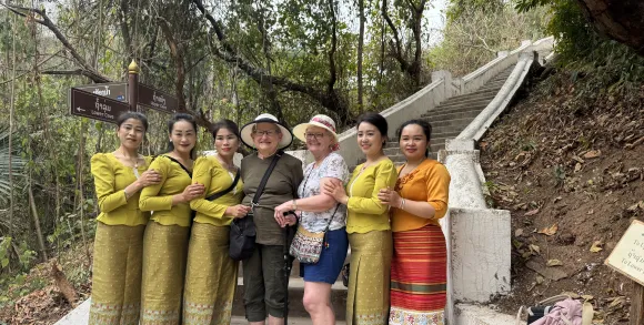 Travellers posing with local women in traditional dress.