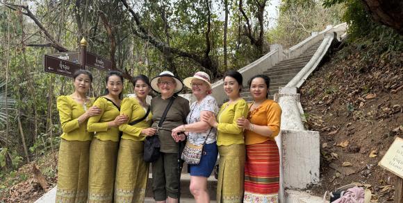 Travellers posing with local women in traditional dress.